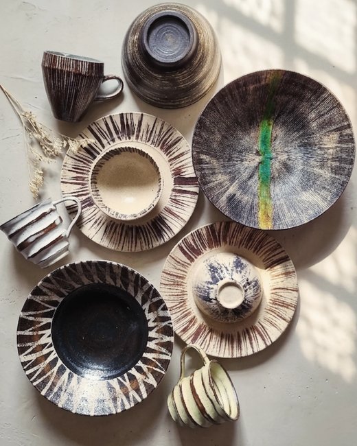 Flat lay of striped and dotted glazed plates and cups, from @obsidianandflame