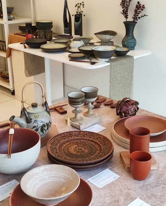 Handmade teapot, cups and plates arranged on a table